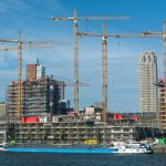 A modern construction site with multiple cranes and buildings in progress.
