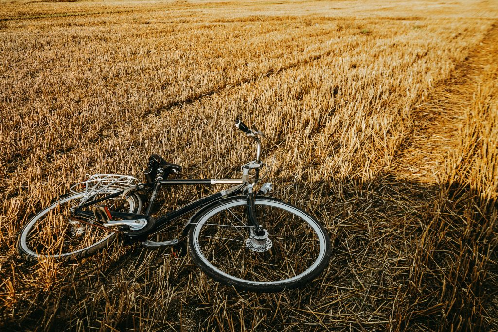 A vintage bicycle lies on a golden field in Minsk, Belarus, capturing the serene countryside landscape.