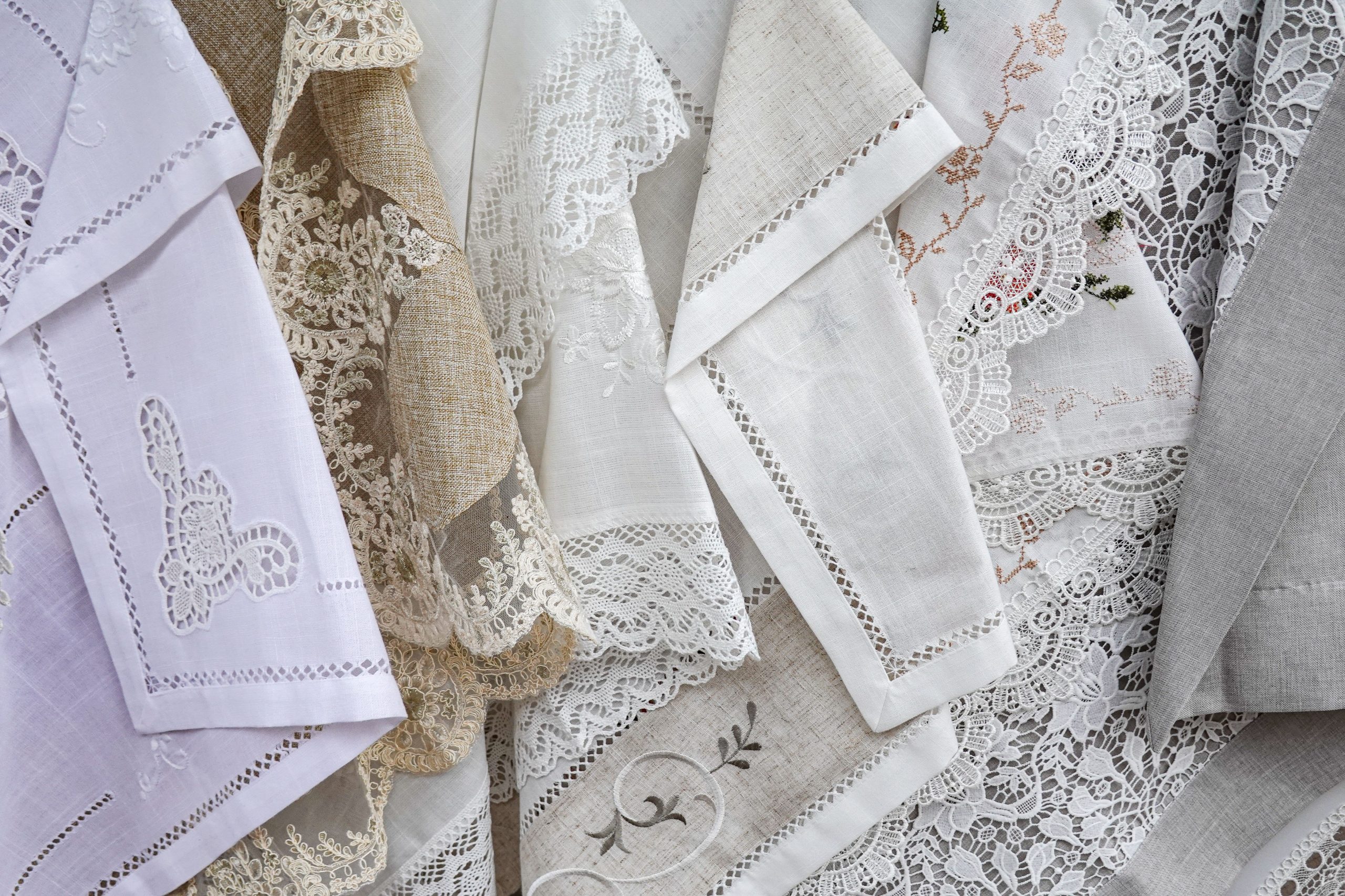 A beautiful collection of lace and linen fabrics showcasing intricate designs and textures.