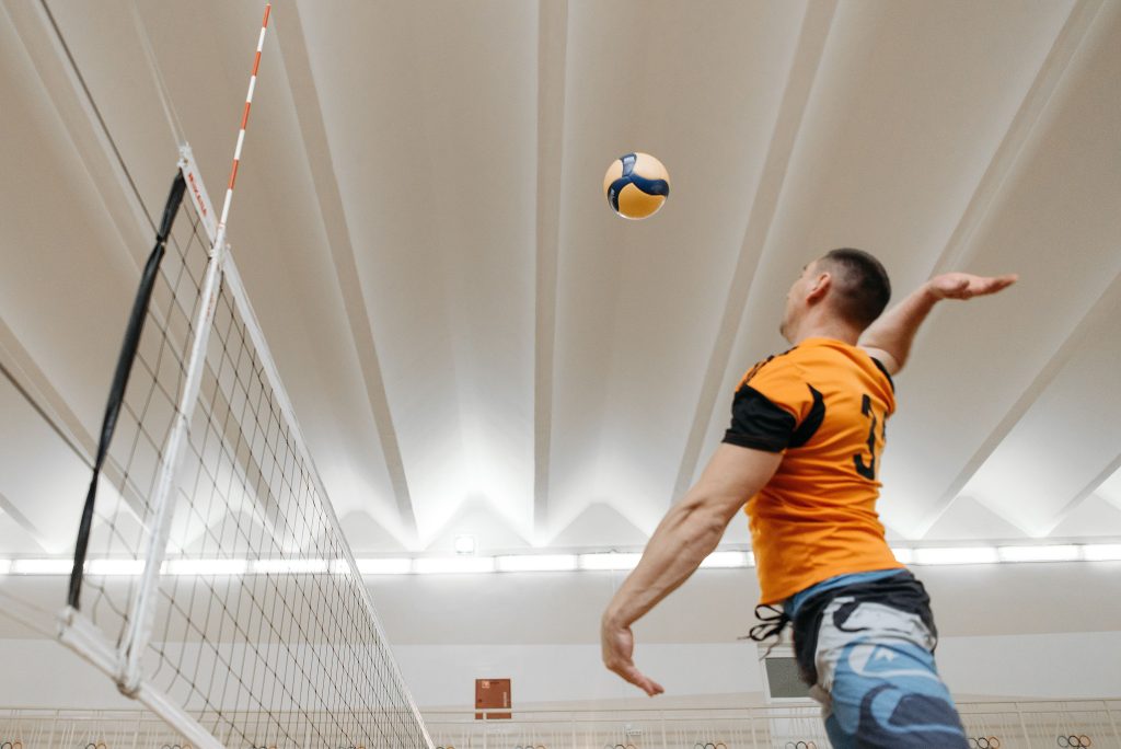 Dynamic shot of a male volleyball player spiking the ball during an indoor match.